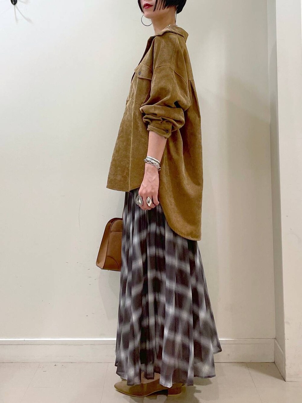 ホワイト系のキャミソール、イエロー系のシャツ/ブラウス、ブラウン系のスカートを着用したレディースの秋コーディネートの5枚目の写真