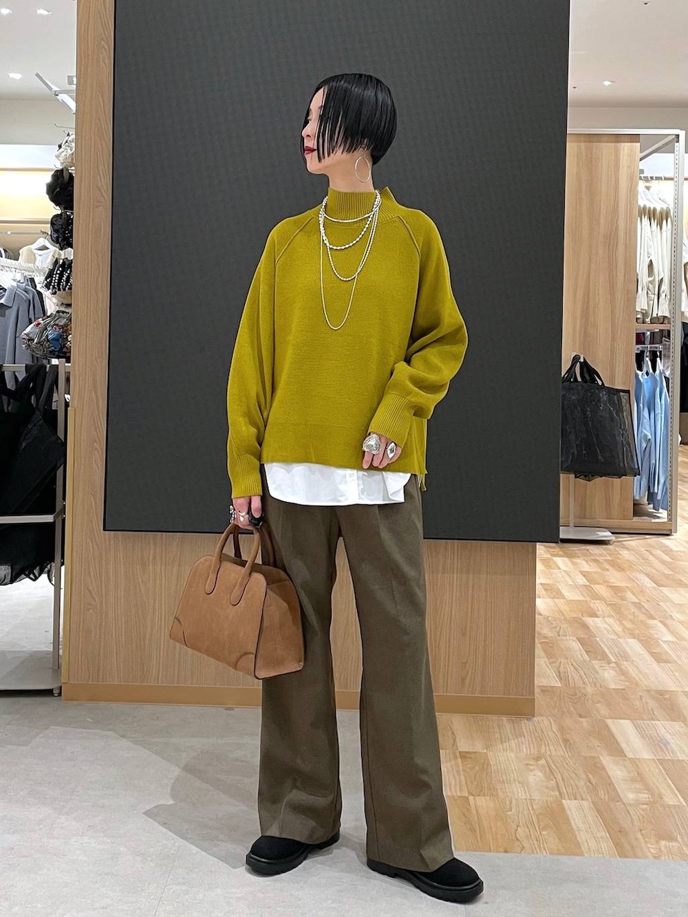 ベージュ系のダウンジャケット/コート、ブラウン系のその他パンツ、ベージュ系のショルダーバッグを着用したレディースの冬コーディネートの9枚目の写真