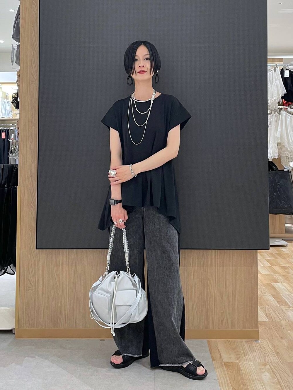 ブラック系のTシャツ/カットソー、ブラック系のサンダル、グレー系のショルダーバッグを着用したレディースの夏コーディネートの7枚目の写真