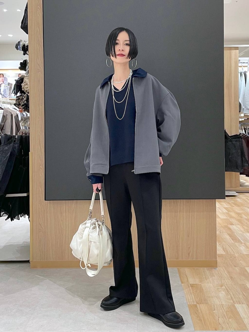 ブラック系のローファー、ホワイト系のショルダーバッグ、ブラック系のスウェットパンツを着用したレディースの春コーディネートの2枚目の写真