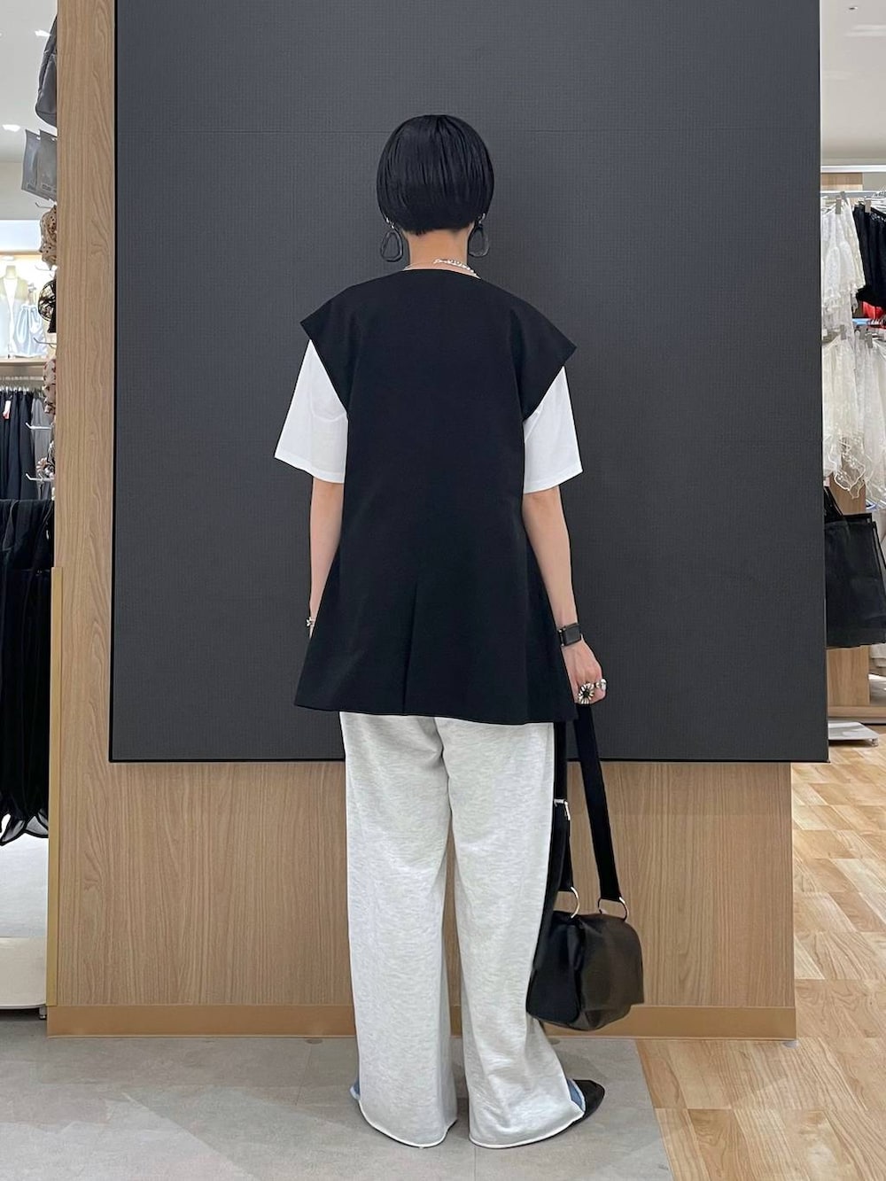 ブラック系のその他シューズ、ホワイト系のTシャツ/カットソー、ブラック系のショルダーバッグを着用したレディースの夏コーディネートの3枚目の写真