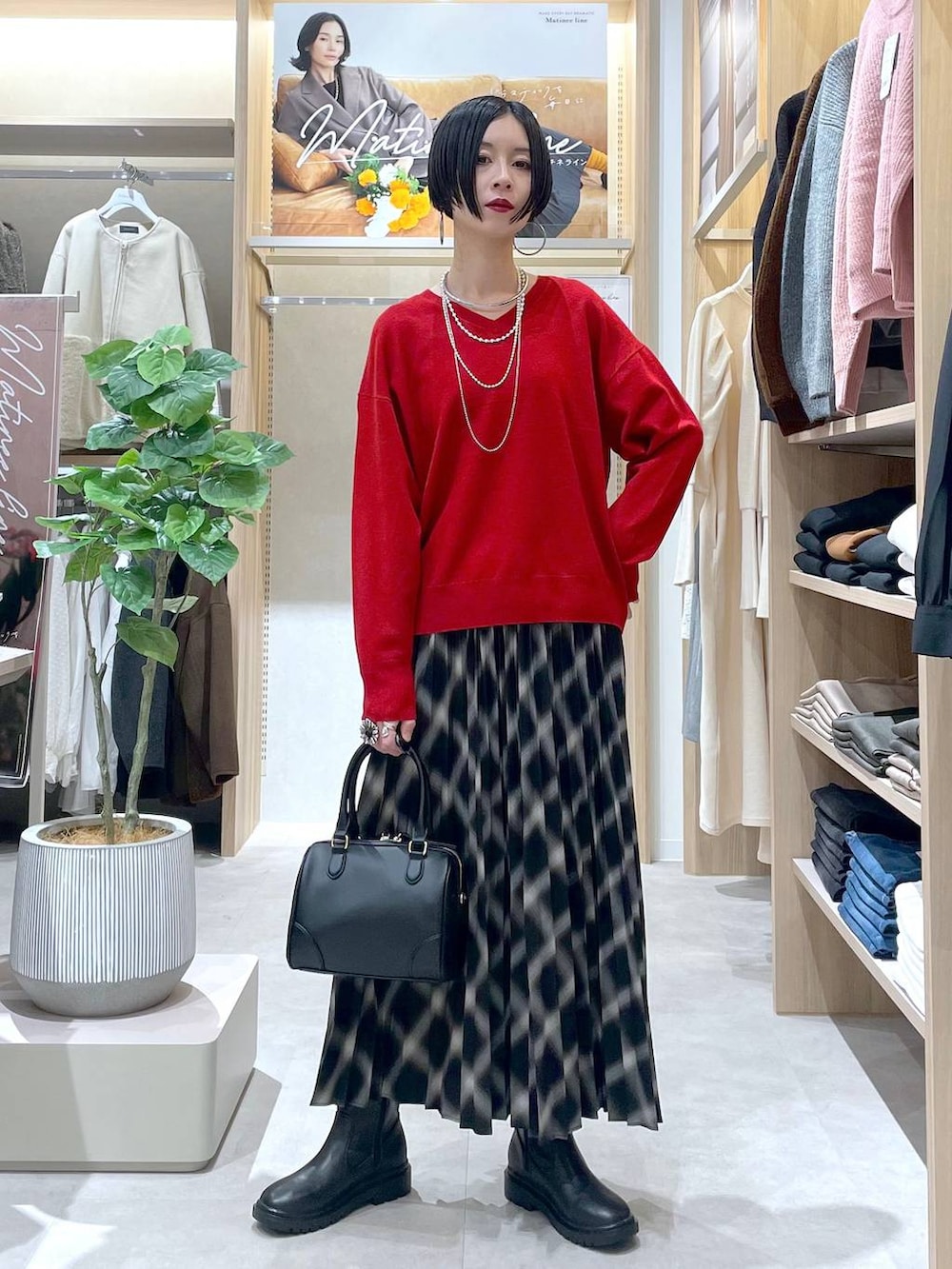 ホワイト系のブルゾン、ブラック系のブーツ、レッド系のニット/セーターを着用したレディースの秋コーディネートの5枚目の写真