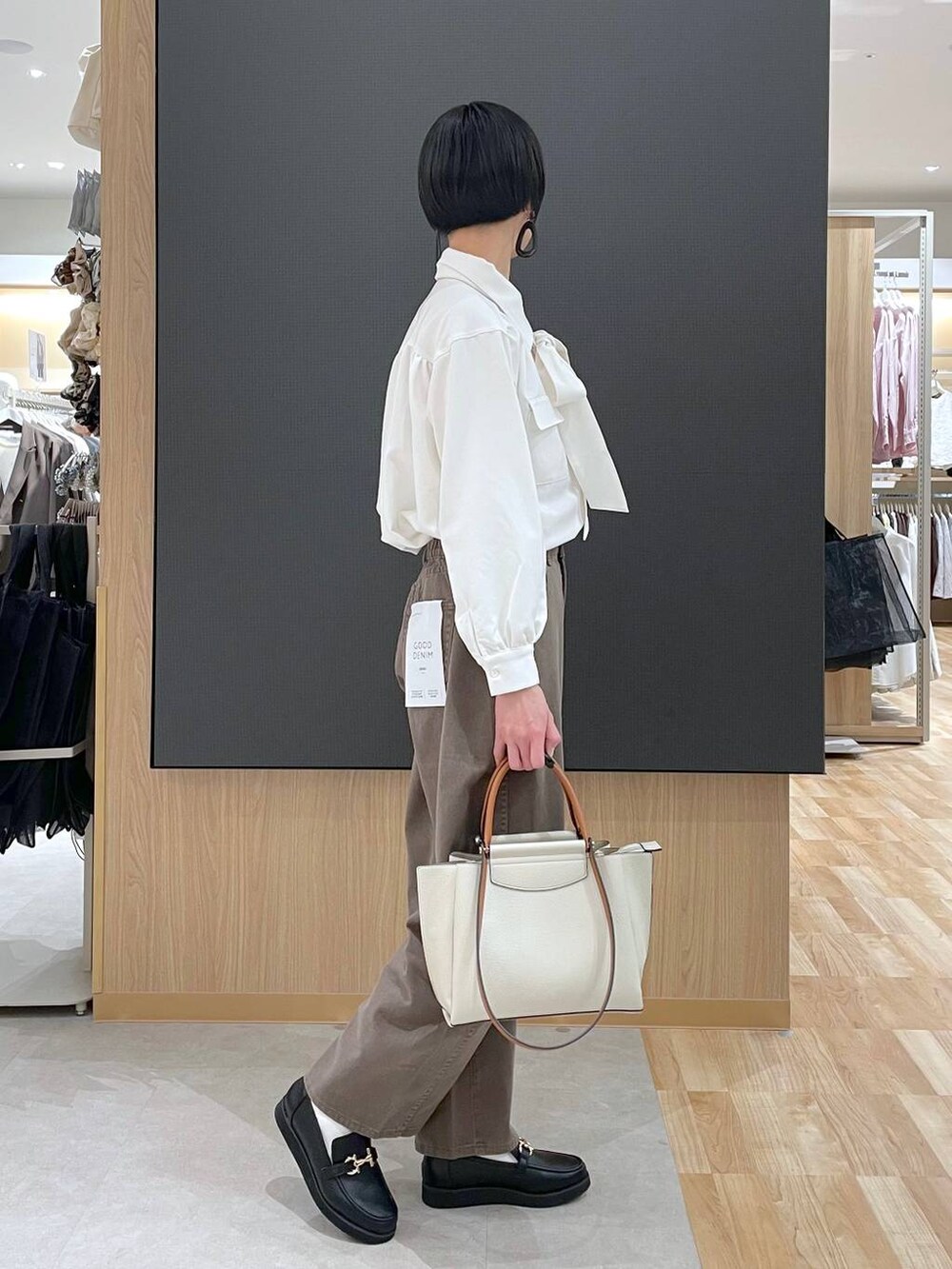 ブラック系のローファー、ブラック系のトートバッグ、ブラウン系のデニムパンツを着用したレディースの春コーディネートの8枚目の写真