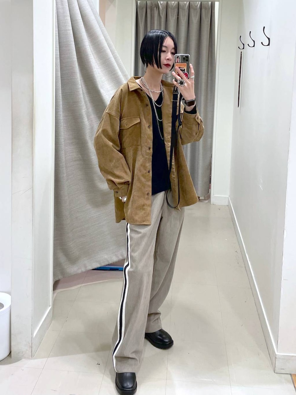 イエロー系のシャツ/ブラウス、ブラック系のスウェット、ブラック系のブーツを着用したレディースの秋コーディネートの2枚目の写真