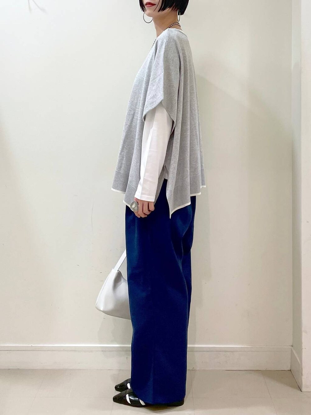 ホワイト系のショルダーバッグ、ホワイト系のTシャツ/カットソー、グレー系のニット/セーターを着用したレディースの春コーディネートの5枚目の写真