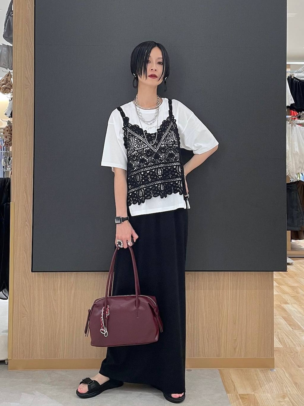 ブラック系のスカート、レッド系のボストンバッグ、ホワイト系のTシャツ/カットソーを着用したレディースの夏コーディネートの6枚目の写真