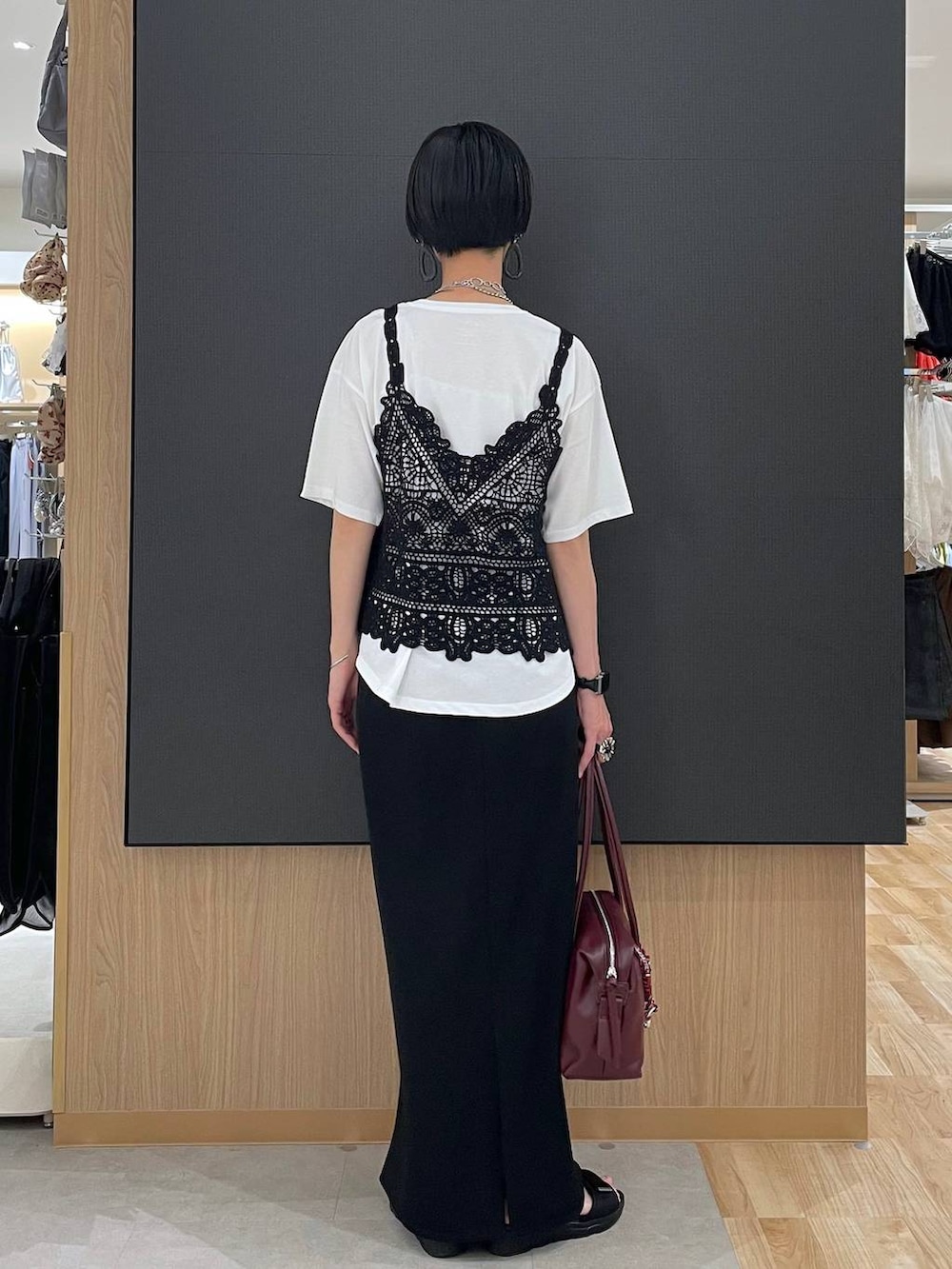 ブラック系のスカート、レッド系のボストンバッグ、ホワイト系のTシャツ/カットソーを着用したレディースの夏コーディネートの4枚目の写真