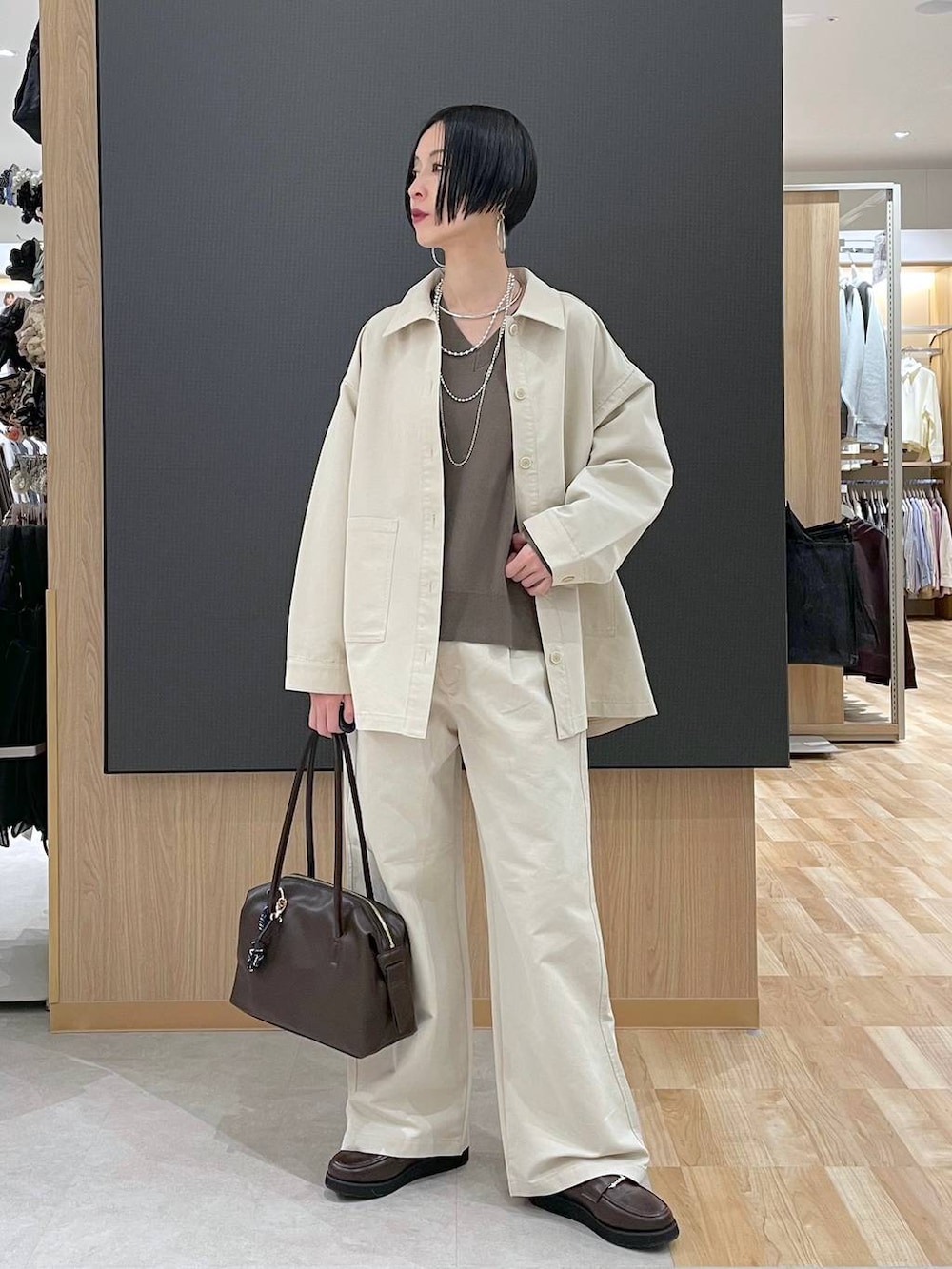 ブラウン系のローファー、ブラウン系のボストンバッグ、ベージュ系のニット/セーターを着用したレディースの春コーディネートの6枚目の写真