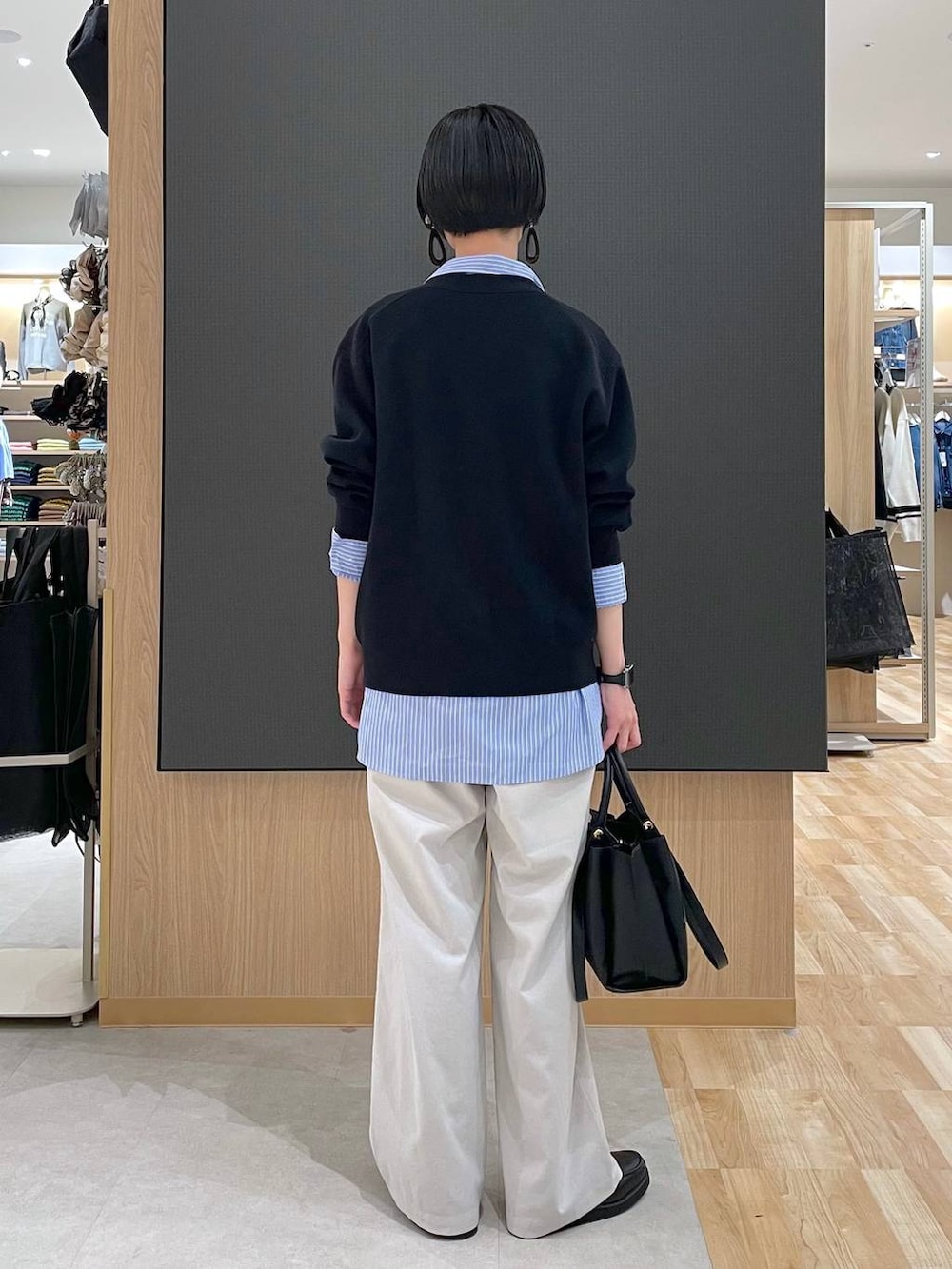 ブラック系のローファー、ブラック系のトートバッグ、ブルー系のシャツ/ブラウスを着用したレディースの春コーディネートの3枚目の写真