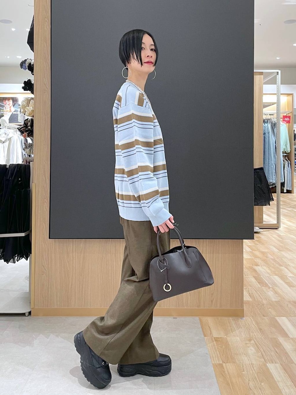 ブラウン系のショルダーバッグ、ブラウン系のその他パンツ、シルバー系のネックレスを着用したレディースの冬コーディネートの2枚目の写真