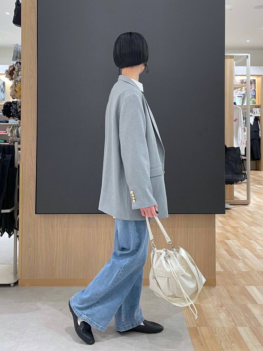 ブラック系のその他シューズ、ホワイト系のショルダーバッグ、ブルー系のデニムパンツを着用したレディースの春コーディネートの3枚目の写真