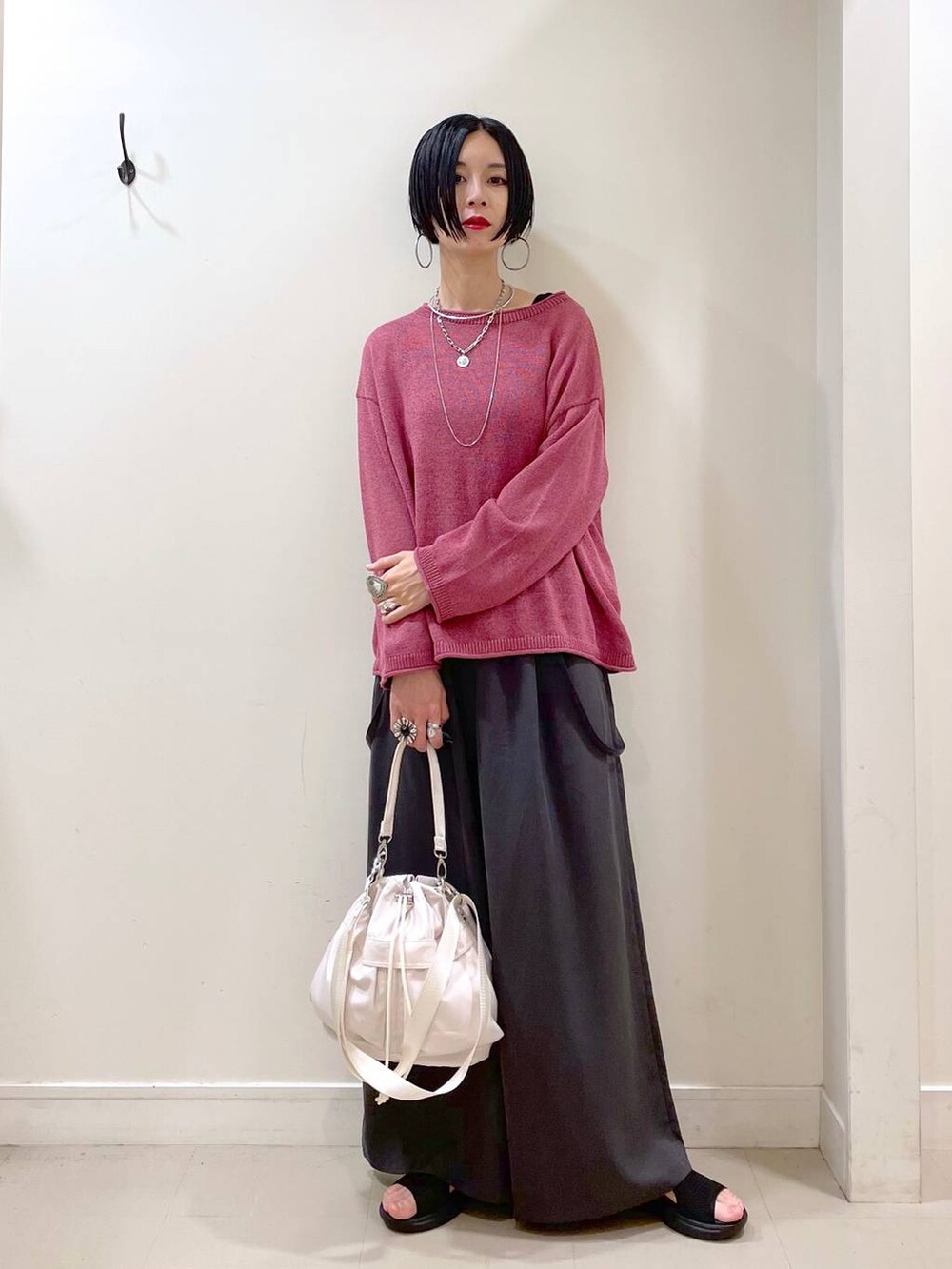 ホワイト系のショルダーバッグ、ブラック系のタンクトップ、ブラック系のサンダルを着用したレディースの秋コーディネートの2枚目の写真