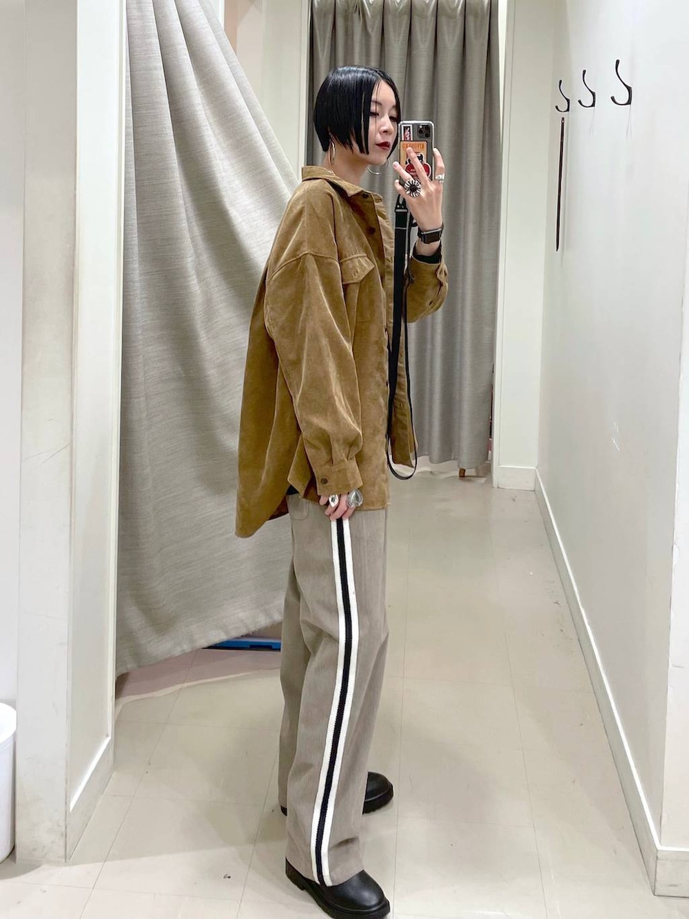 イエロー系のシャツ/ブラウス、ブラック系のスウェット、ブラック系のブーツを着用したレディースの秋コーディネートの3枚目の写真