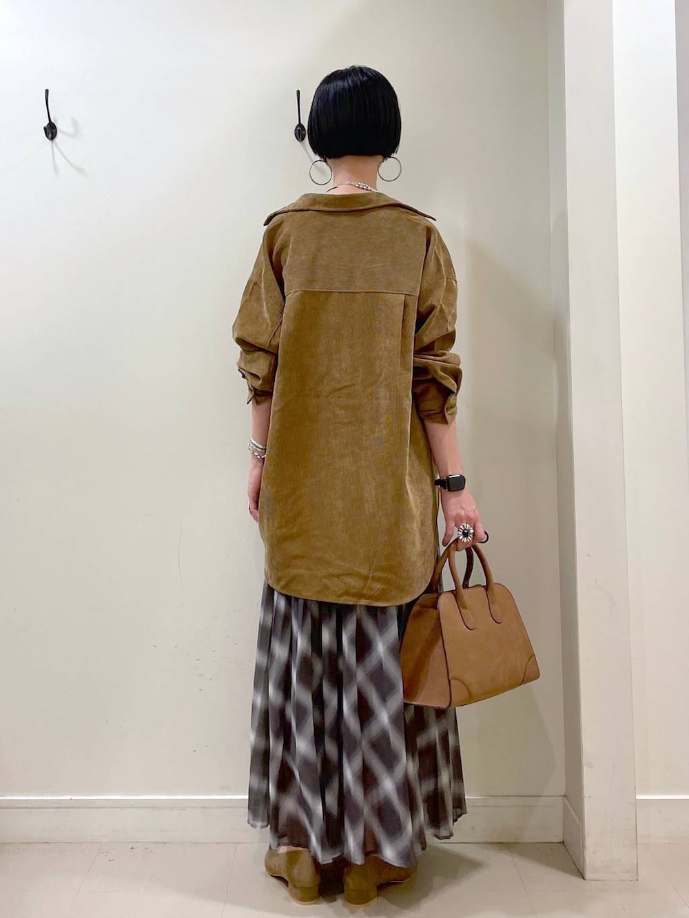ホワイト系のキャミソール、イエロー系のシャツ/ブラウス、ブラウン系のスカートを着用したレディースの秋コーディネートの4枚目の写真
