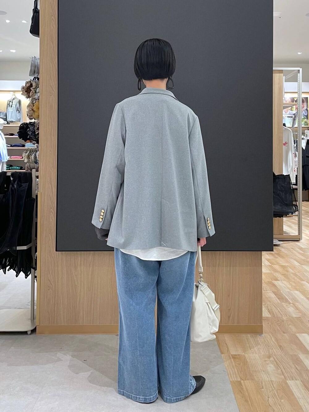 ブラック系のその他シューズ、ホワイト系のショルダーバッグ、ブルー系のデニムパンツを着用したレディースの春コーディネートの4枚目の写真