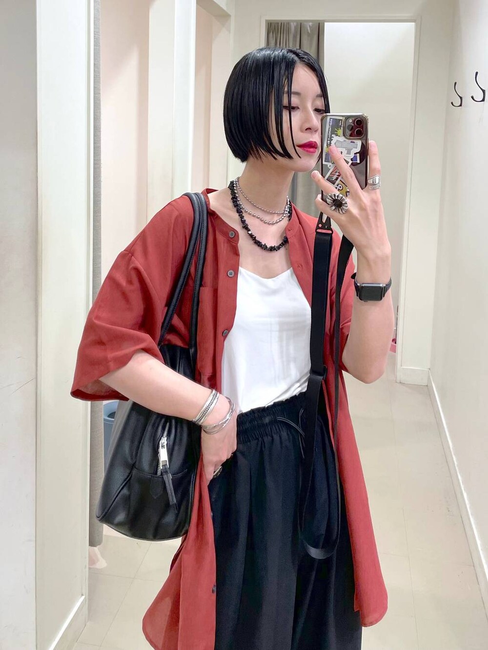 ブラック系のショルダーバッグ、ブラック系のその他パンツ、オレンジ系のシャツ/ブラウスを着用したレディースの夏コーディネートの5枚目の写真