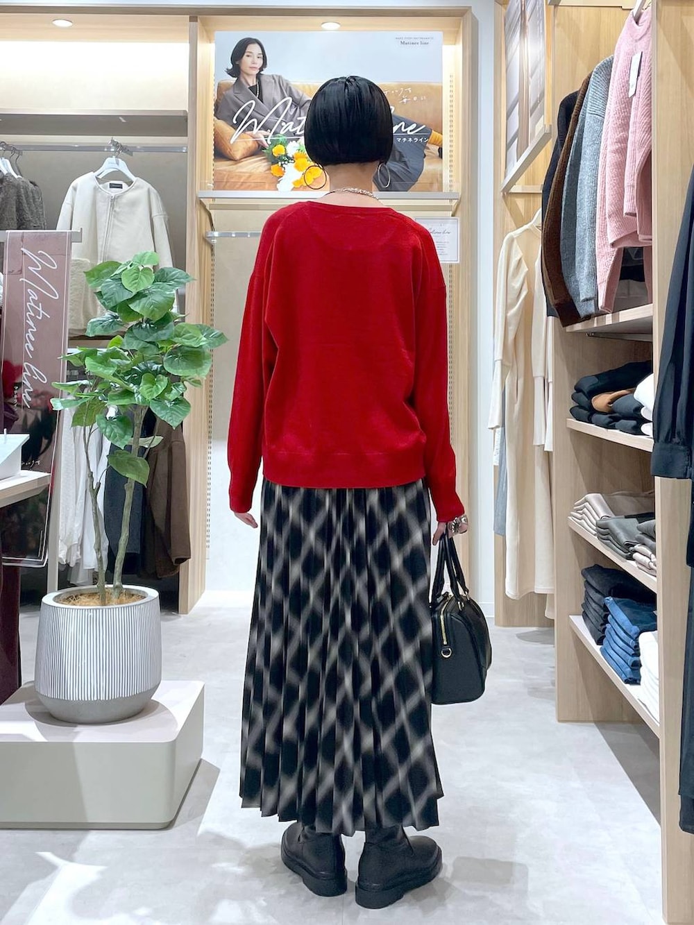 ホワイト系のブルゾン、ブラック系のブーツ、レッド系のニット/セーターを着用したレディースの秋コーディネートの7枚目の写真