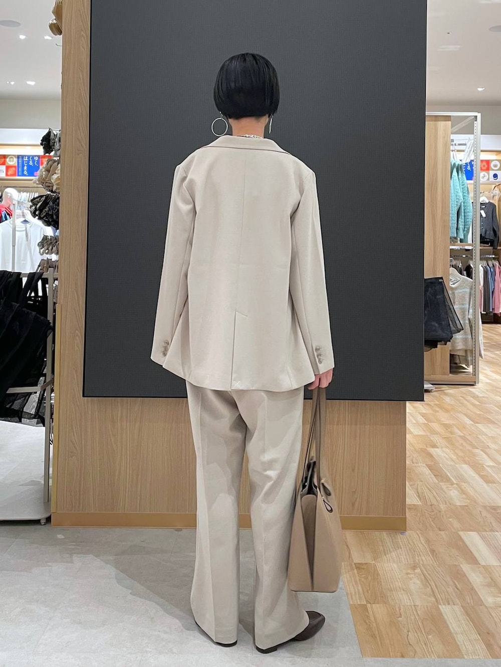 ブラウン系のローファー、ブラウン系のニット/セーター、ベージュ系のトートバッグを着用したレディースの冬コーディネートの3枚目の写真