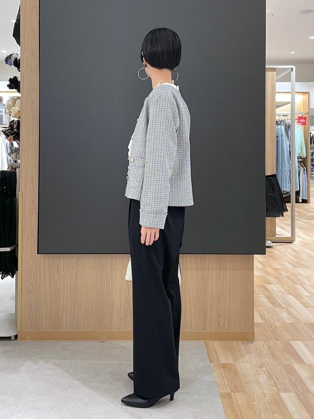 ホワイト系のショルダーバッグ、ブラック系のパンプス、ブラック系のスラックスを着用したレディースの冬コーディネートの5枚目の写真