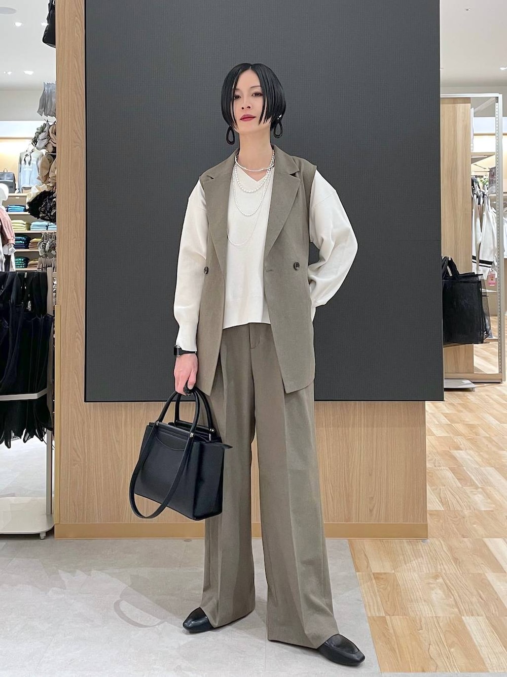 ブラック系のその他シューズ、ブラック系のトートバッグ、ベージュ系のニット/セーターを着用したレディースの春コーディネートの2枚目の写真