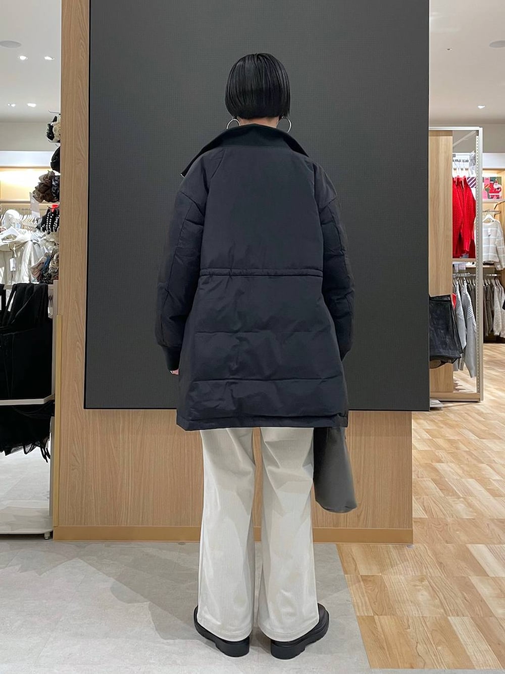 ブラック系のダウンジャケット/コート、グレー系のその他パンツ、ブラック系のブーツを着用したレディースの冬コーディネートの4枚目の写真