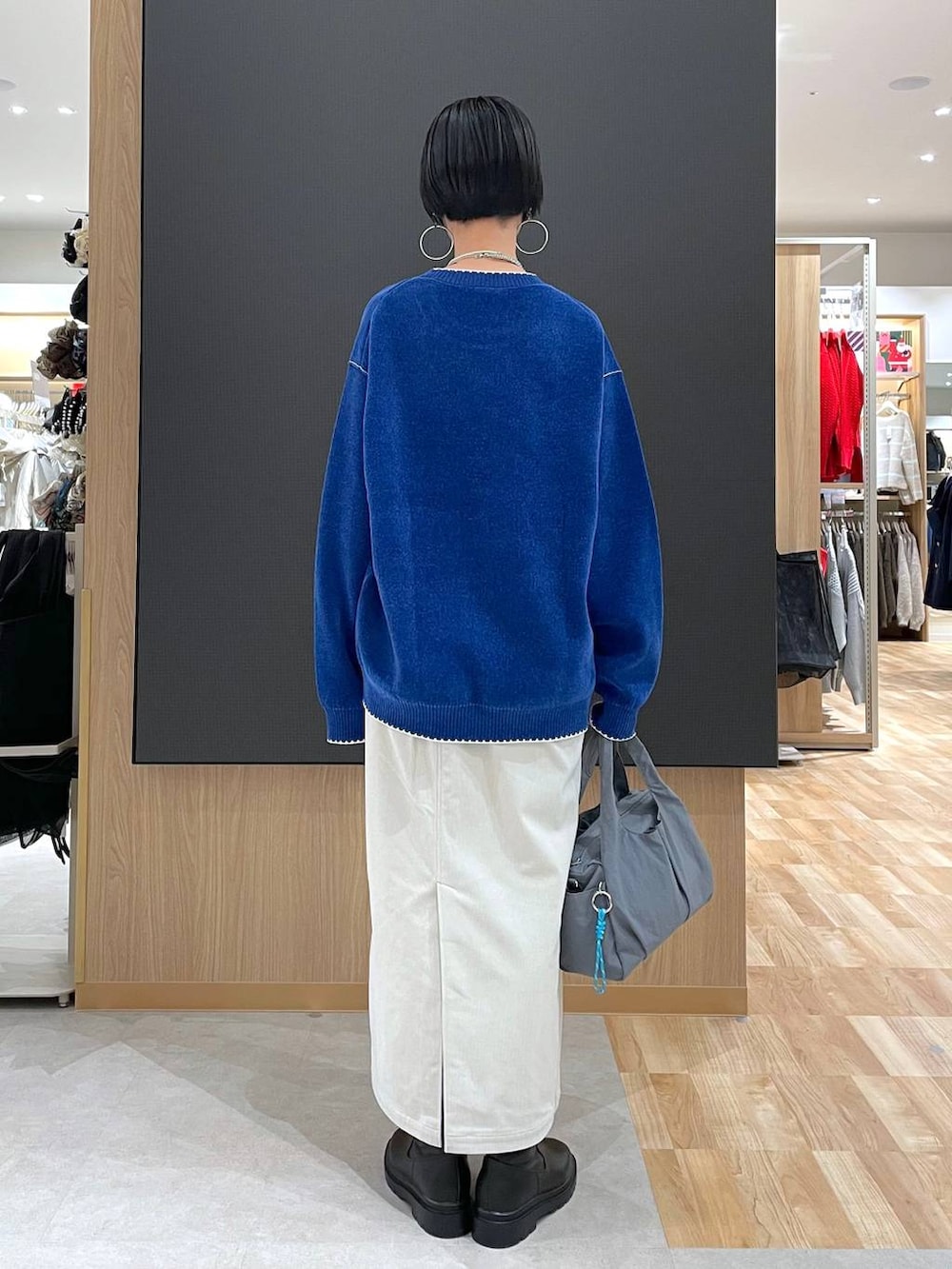 グレー系のトートバッグ、ブラック系のブルゾン、グレー系のスカートを着用したレディースの冬コーディネートの9枚目の写真