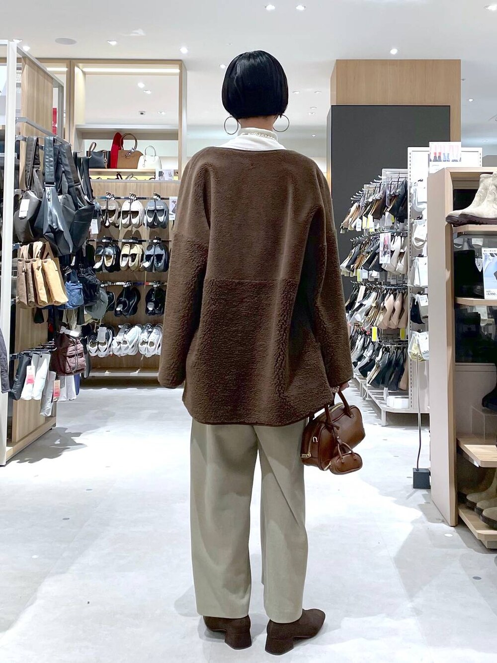 ブラウン系のハンドバッグ、ベージュ系のサロペット/オーバーオール、ホワイト系のニット/セーターを着用したレディースの秋コーディネートの7枚目の写真