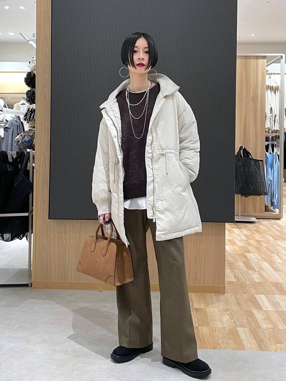 ベージュ系のダウンジャケット/コート、ブラウン系のその他パンツ、ベージュ系のショルダーバッグを着用したレディースの秋コーディネートの2枚目の写真