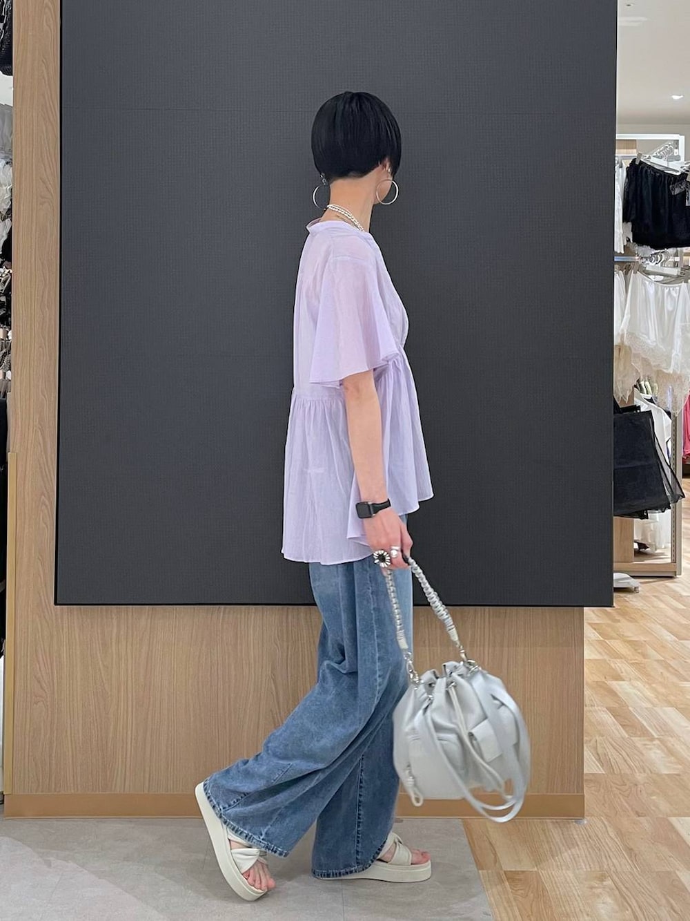 ホワイト系のキャミソール、ブルー系のデニムパンツ、ホワイト系のサンダルを着用したレディースの夏コーディネートの2枚目の写真