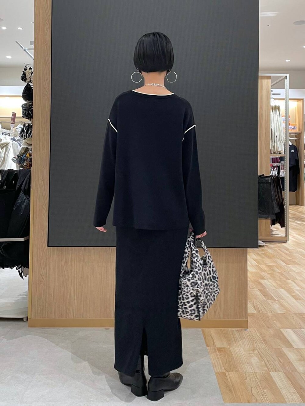 その他のトートバッグ、ブラック系のワンピース、ブラック系のブーツを着用したレディースの冬コーディネートの4枚目の写真