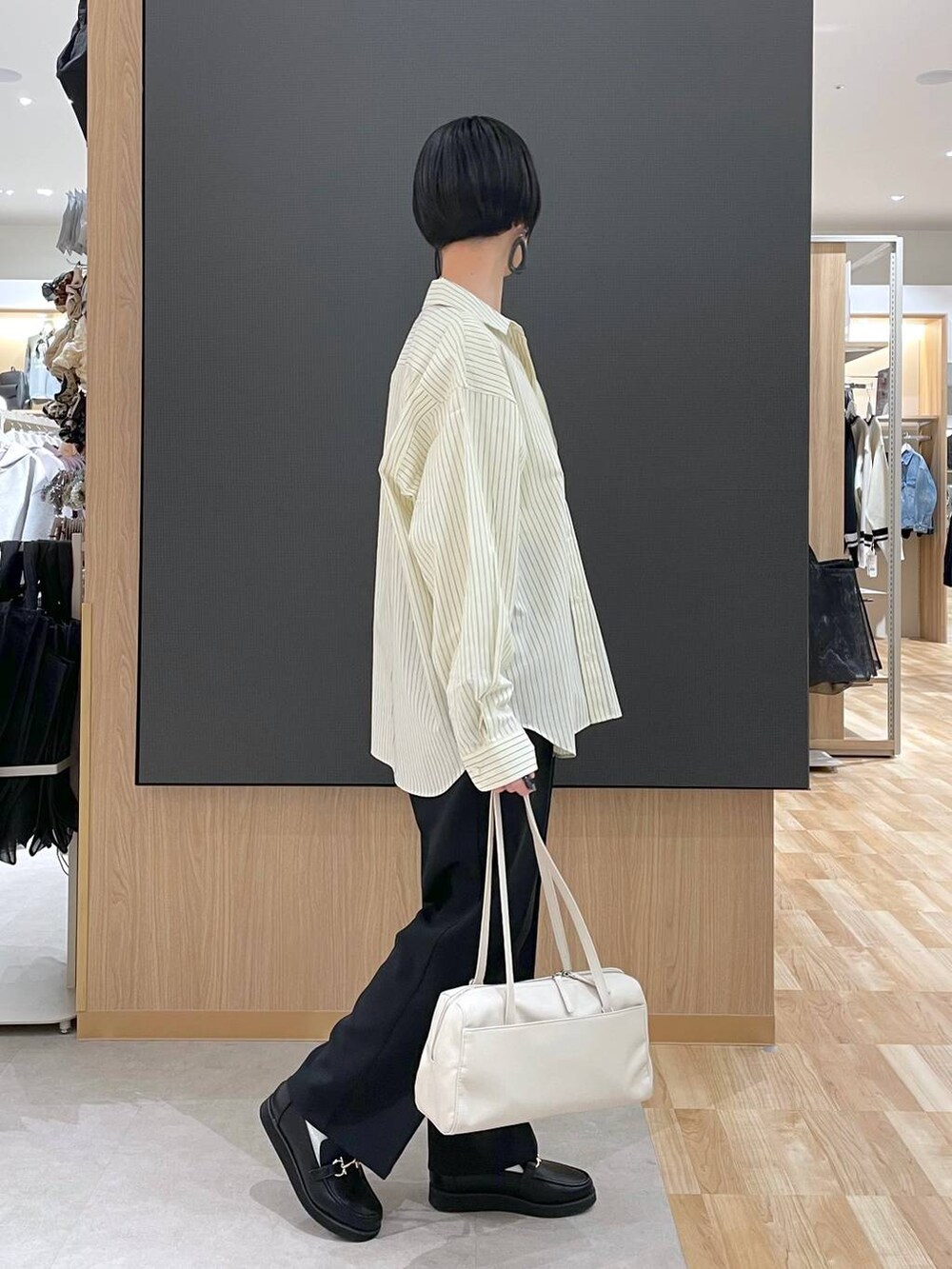 ブラック系のローファー、ブラック系のその他パンツ、ベージュ系のショルダーバッグを着用したレディースの春コーディネートの3枚目の写真