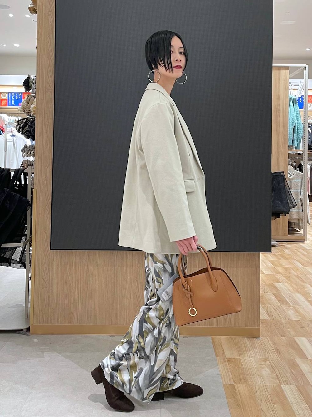 ブラウン系のショルダーバッグ、ブラウン系のニット/セーター、ブラウン系のブーツを着用したレディースの冬コーディネートの3枚目の写真