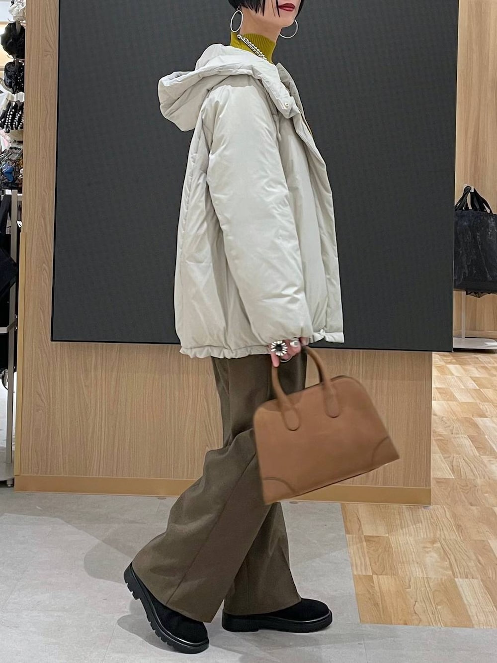 ベージュ系のダウンジャケット/コート、ブラウン系のその他パンツ、ベージュ系のショルダーバッグを着用したレディースの冬コーディネートの3枚目の写真