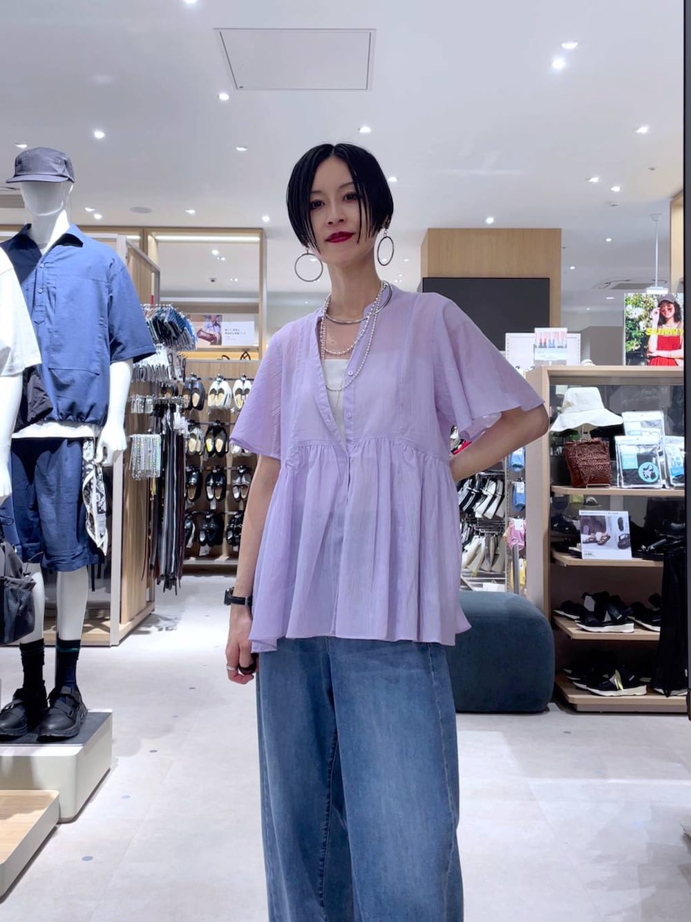 ホワイト系のキャミソール、ブルー系のデニムパンツ、ホワイト系のサンダルを着用したレディースの夏コーディネートの5枚目の写真