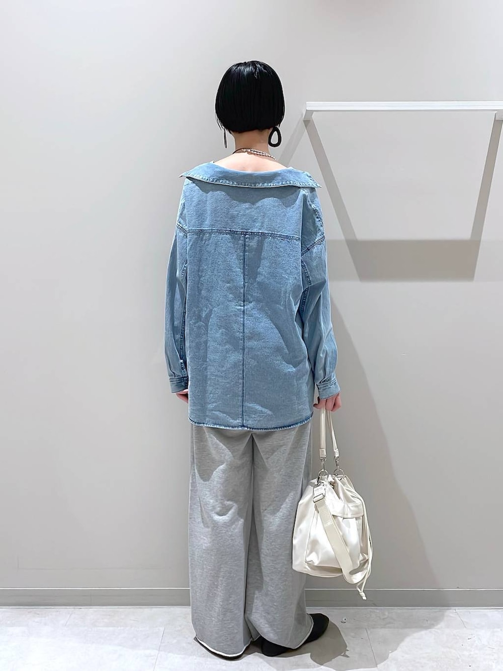 ブラック系のその他シューズ、ホワイト系のショルダーバッグ、グレー系のスウェットパンツを着用したレディースの春コーディネートの3枚目の写真