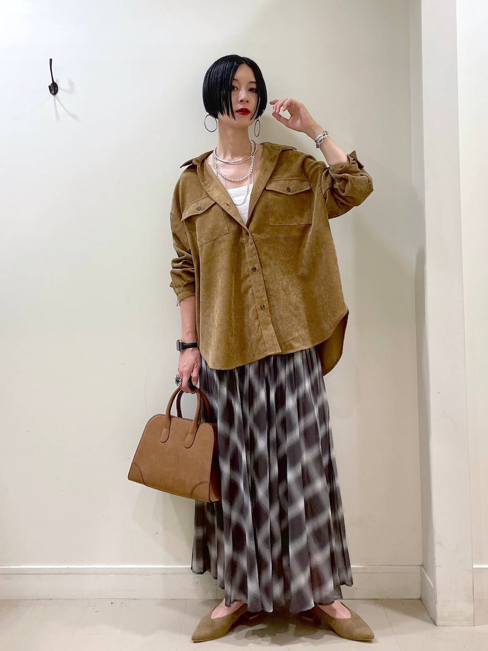 ホワイト系のキャミソール、イエロー系のシャツ/ブラウス、ブラウン系のスカートを着用したレディースの秋コーディネートの2枚目の写真