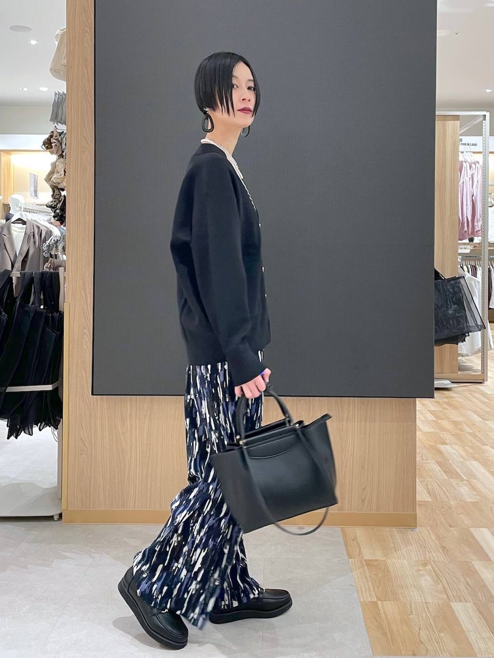 ブラック系のローファー、ブラック系のブルゾン、ブラック系のトートバッグを着用したレディースの春コーディネートの7枚目の写真