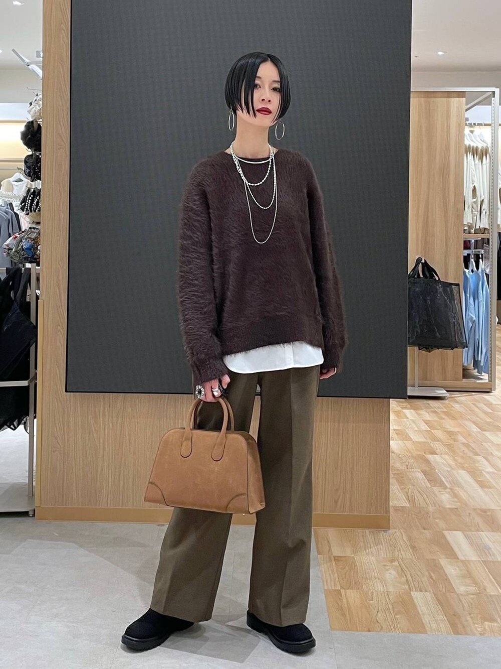 ベージュ系のダウンジャケット/コート、ブラウン系のその他パンツ、ベージュ系のショルダーバッグを着用したレディースの秋コーディネートの5枚目の写真