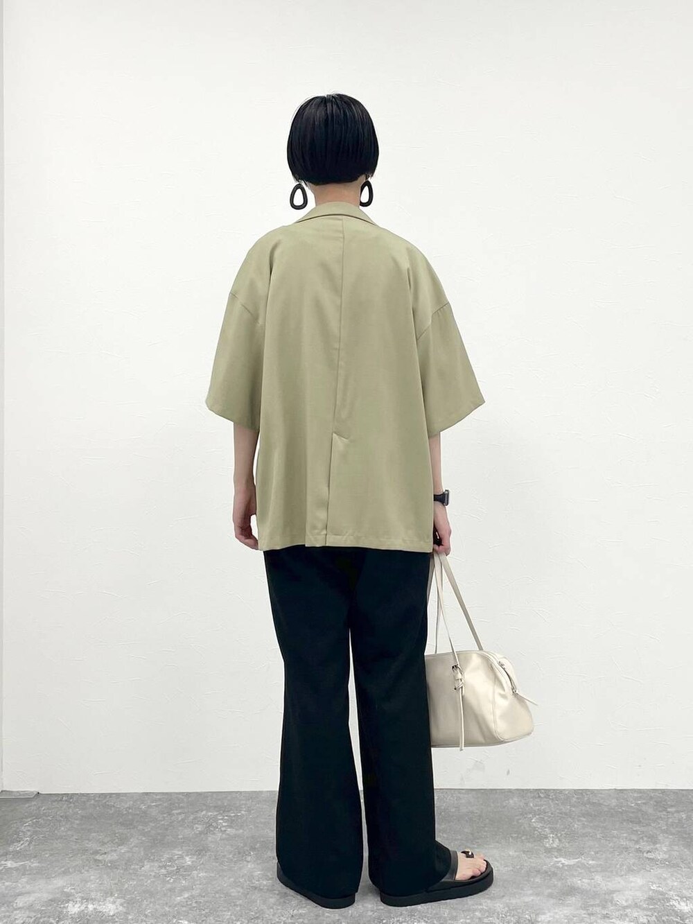 ブラック系のその他パンツ、ホワイト系のTシャツ/カットソー、ベージュ系のショルダーバッグを着用したレディースの春コーディネートの3枚目の写真