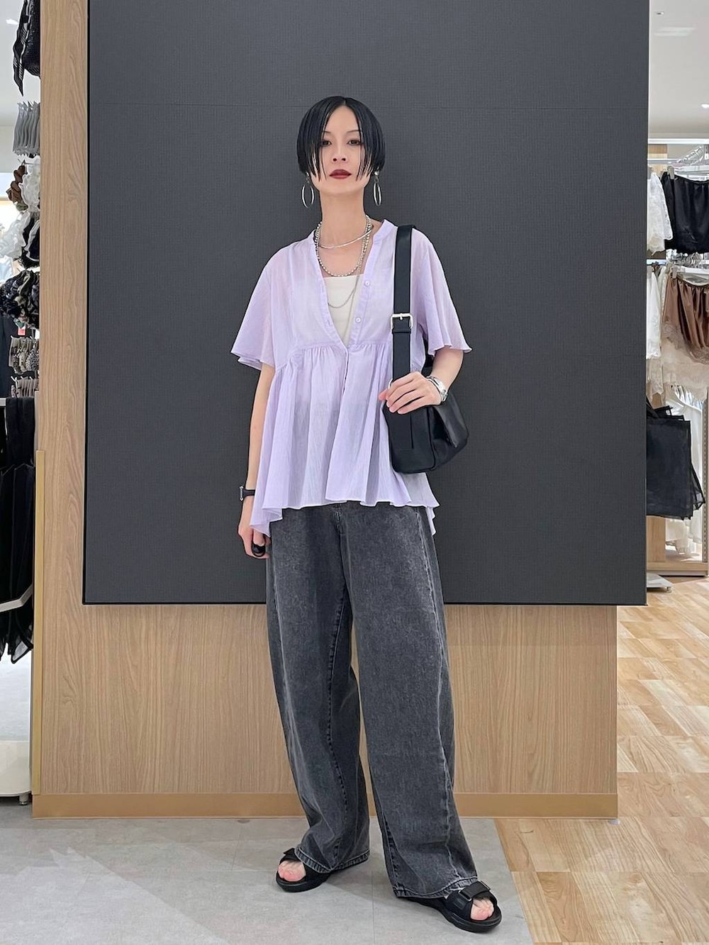 ホワイト系のキャミソール、ブラック系のデニムパンツ、ブラック系のサンダルを着用したレディースの夏コーディネートの6枚目の写真