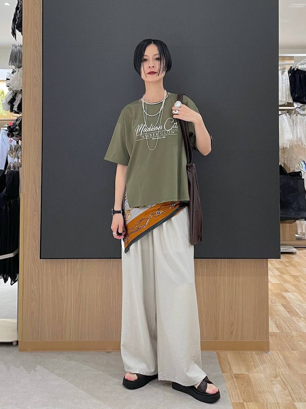 ベージュ系のその他パンツ、グリーン系のTシャツ/カットソー、ブラウン系のサンダルを着用したレディースの夏コーディネートの6枚目の写真