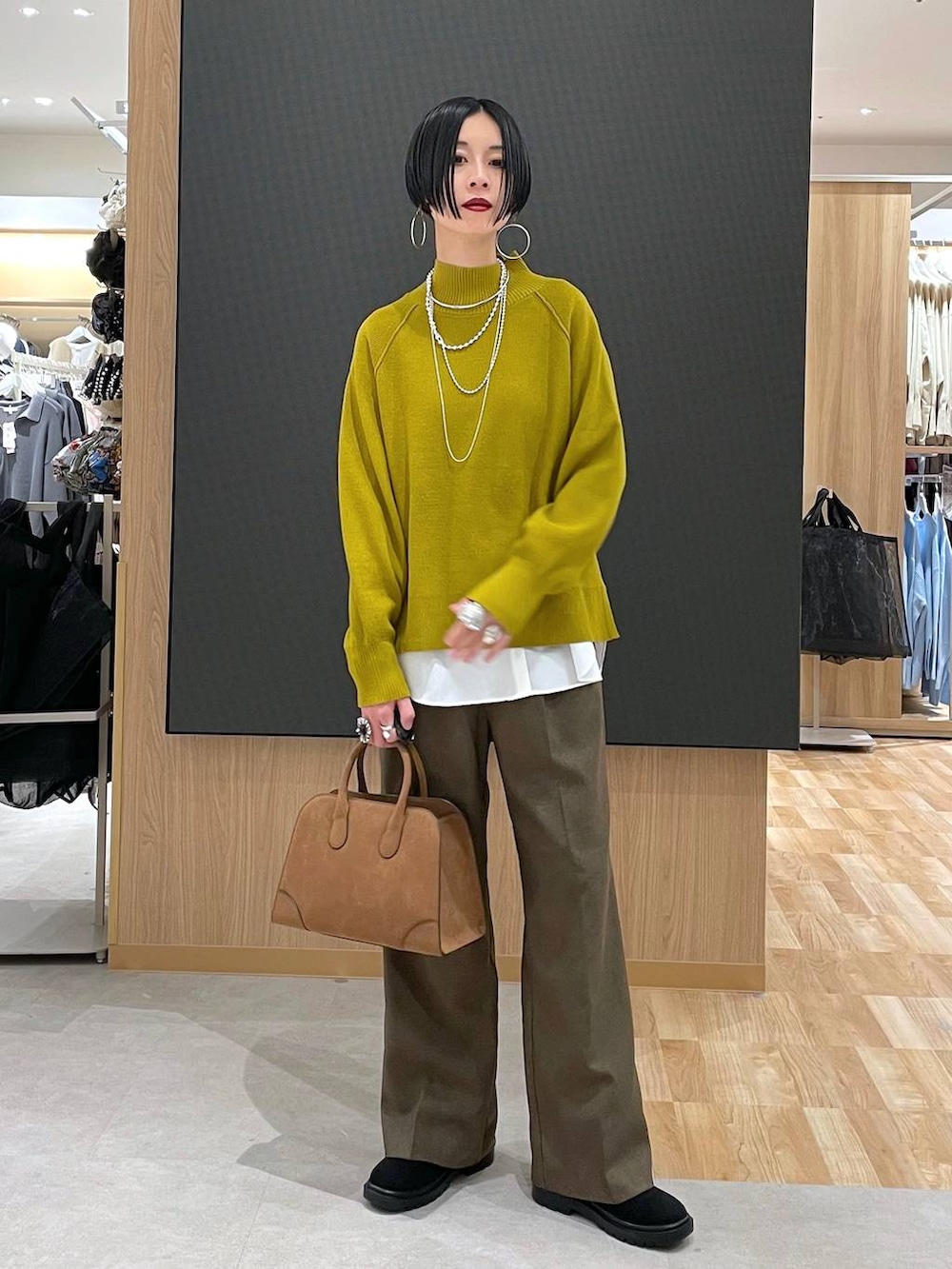 ベージュ系のダウンジャケット/コート、ブラウン系のその他パンツ、ベージュ系のショルダーバッグを着用したレディースの冬コーディネートの6枚目の写真