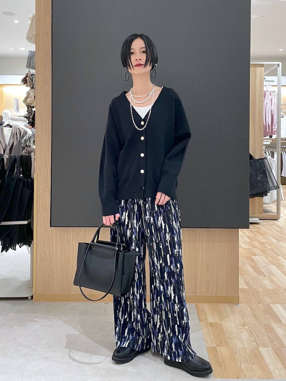 ブラック系のローファー、ブラック系のブルゾン、ブラック系のトートバッグを着用したレディースの春コーディネートの6枚目の写真