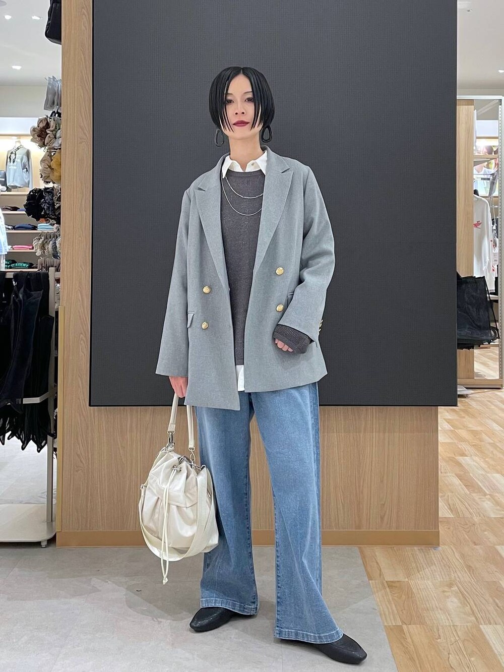 ブラック系のその他シューズ、ホワイト系のショルダーバッグ、ブルー系のデニムパンツを着用したレディースの春コーディネートの2枚目の写真
