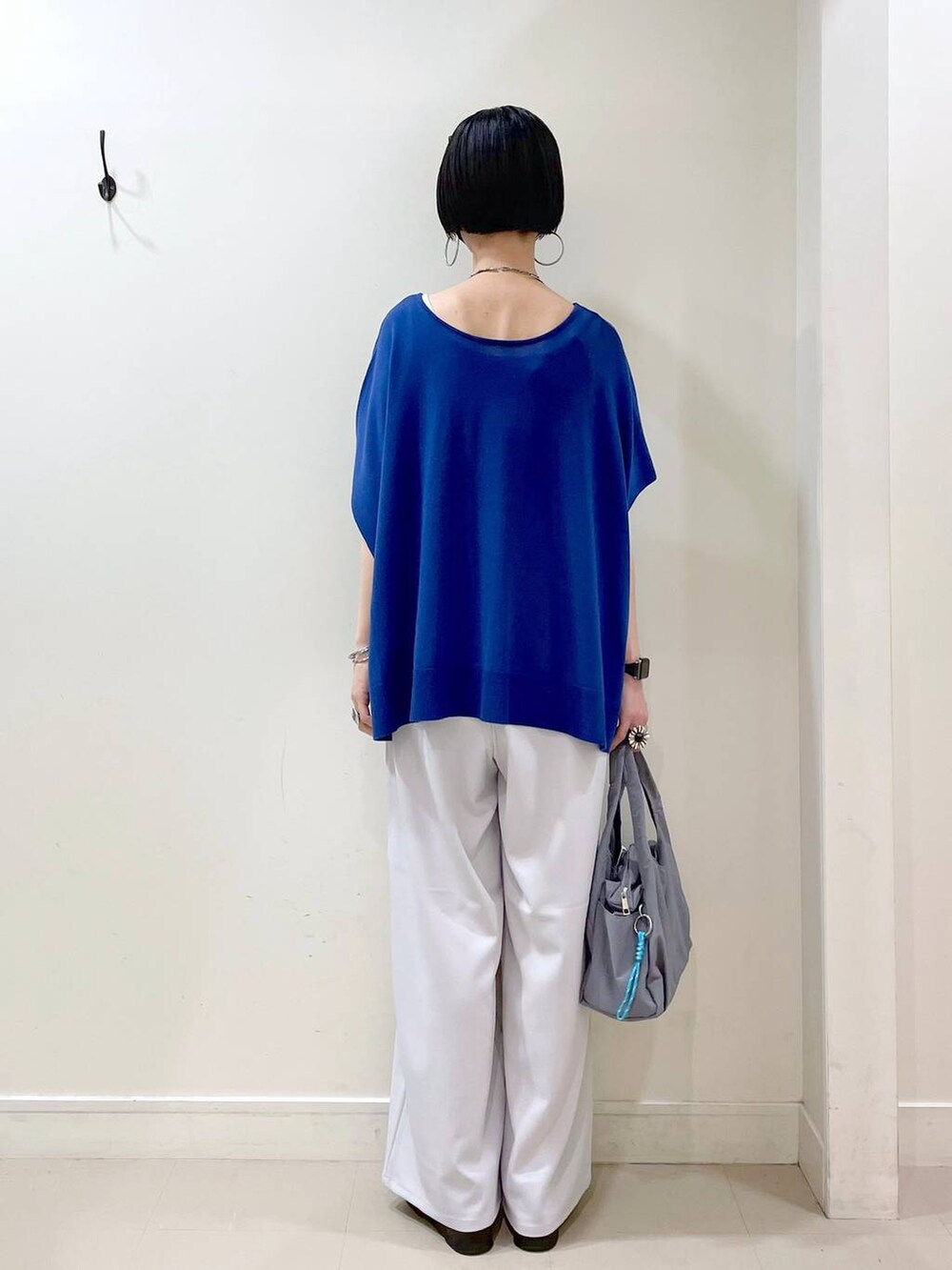 グレー系のその他パンツ、ブルー系のニット/セーター、グレー系のトートバッグを着用したレディースの夏コーディネートの4枚目の写真