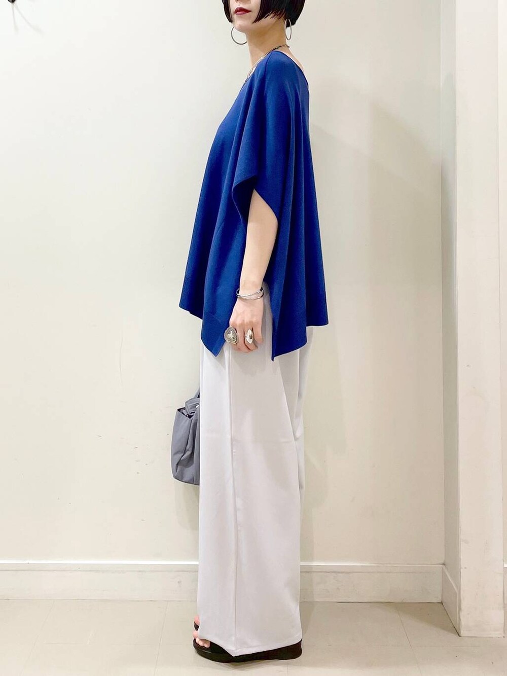 グレー系のその他パンツ、ブルー系のニット/セーター、グレー系のトートバッグを着用したレディースの夏コーディネートの5枚目の写真