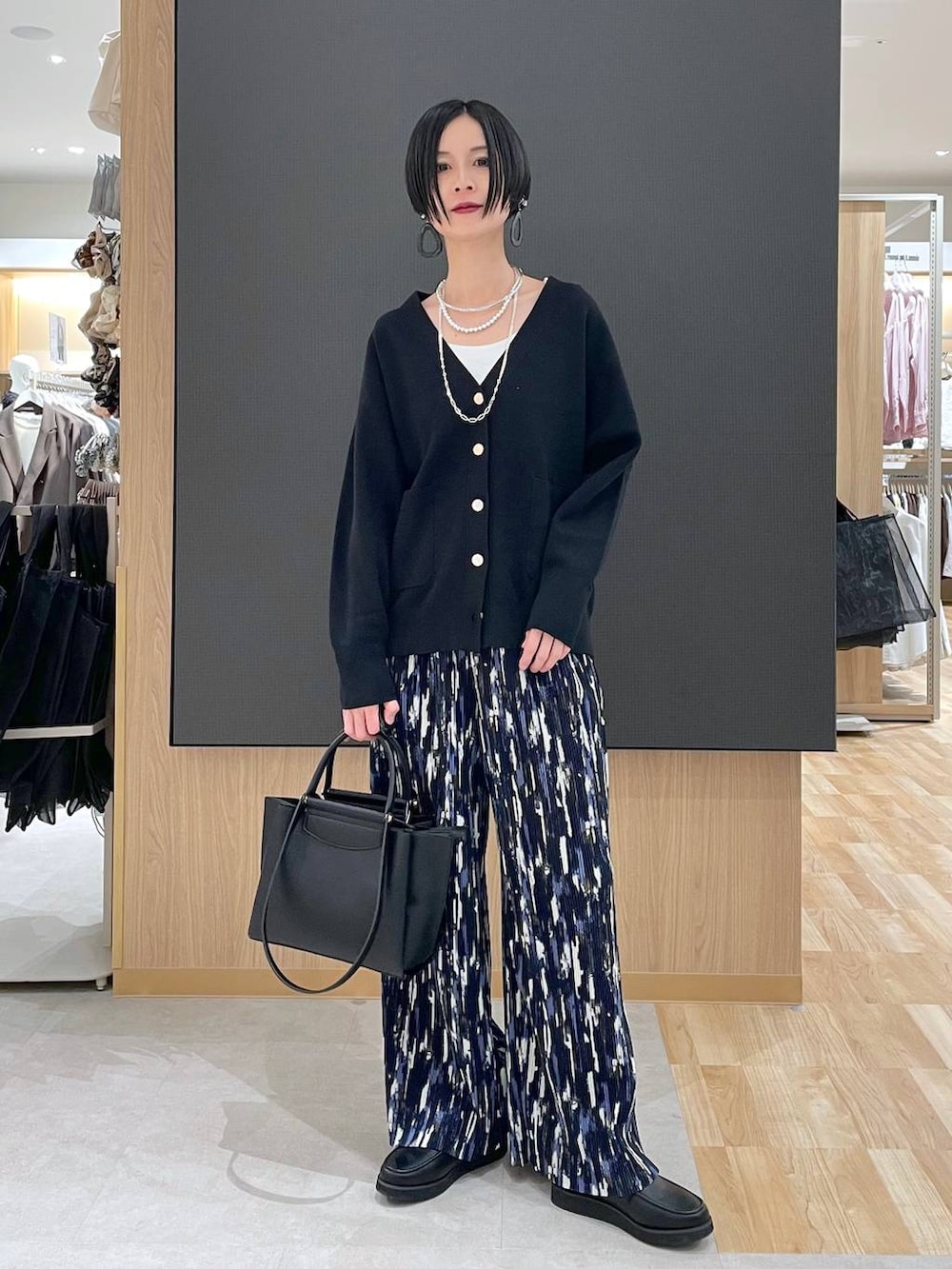 ブラック系のローファー、ブラック系のブルゾン、ブラック系のトートバッグを着用したレディースの春コーディネートの10枚目の写真