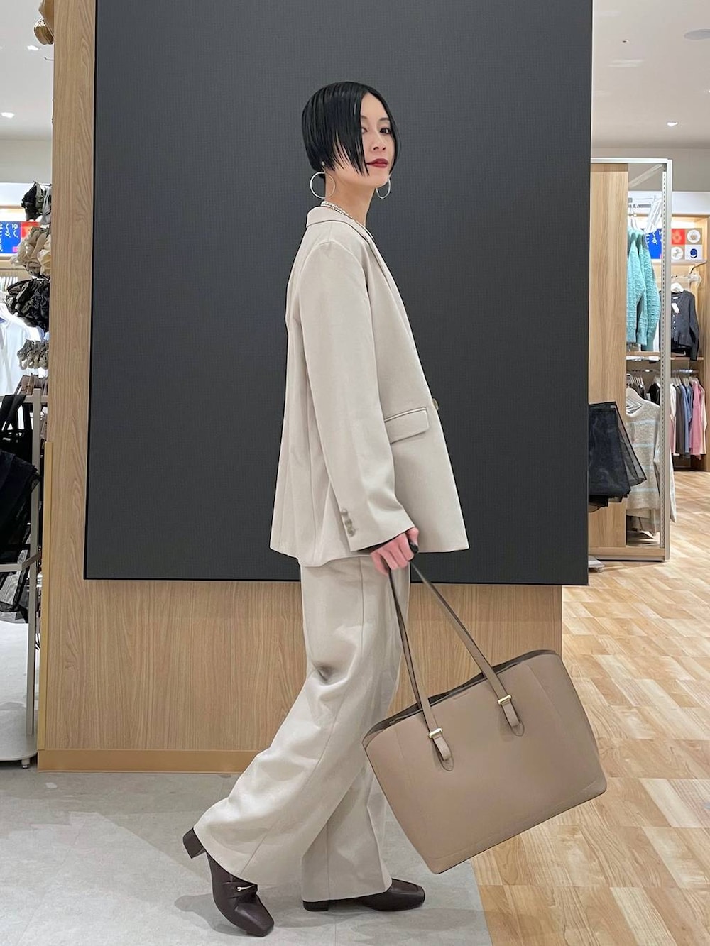 ブラウン系のローファー、ブラウン系のニット/セーター、ベージュ系のトートバッグを着用したレディースの冬コーディネートの2枚目の写真