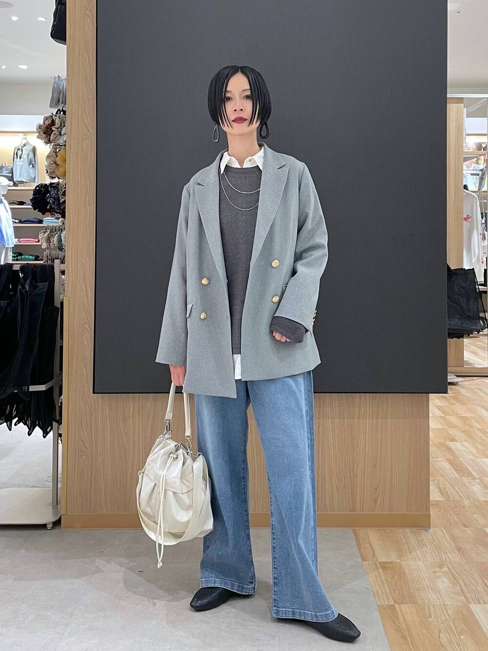 ブラック系のその他シューズ、ホワイト系のショルダーバッグ、ブルー系のデニムパンツを着用したレディースの春コーディネートの6枚目の写真