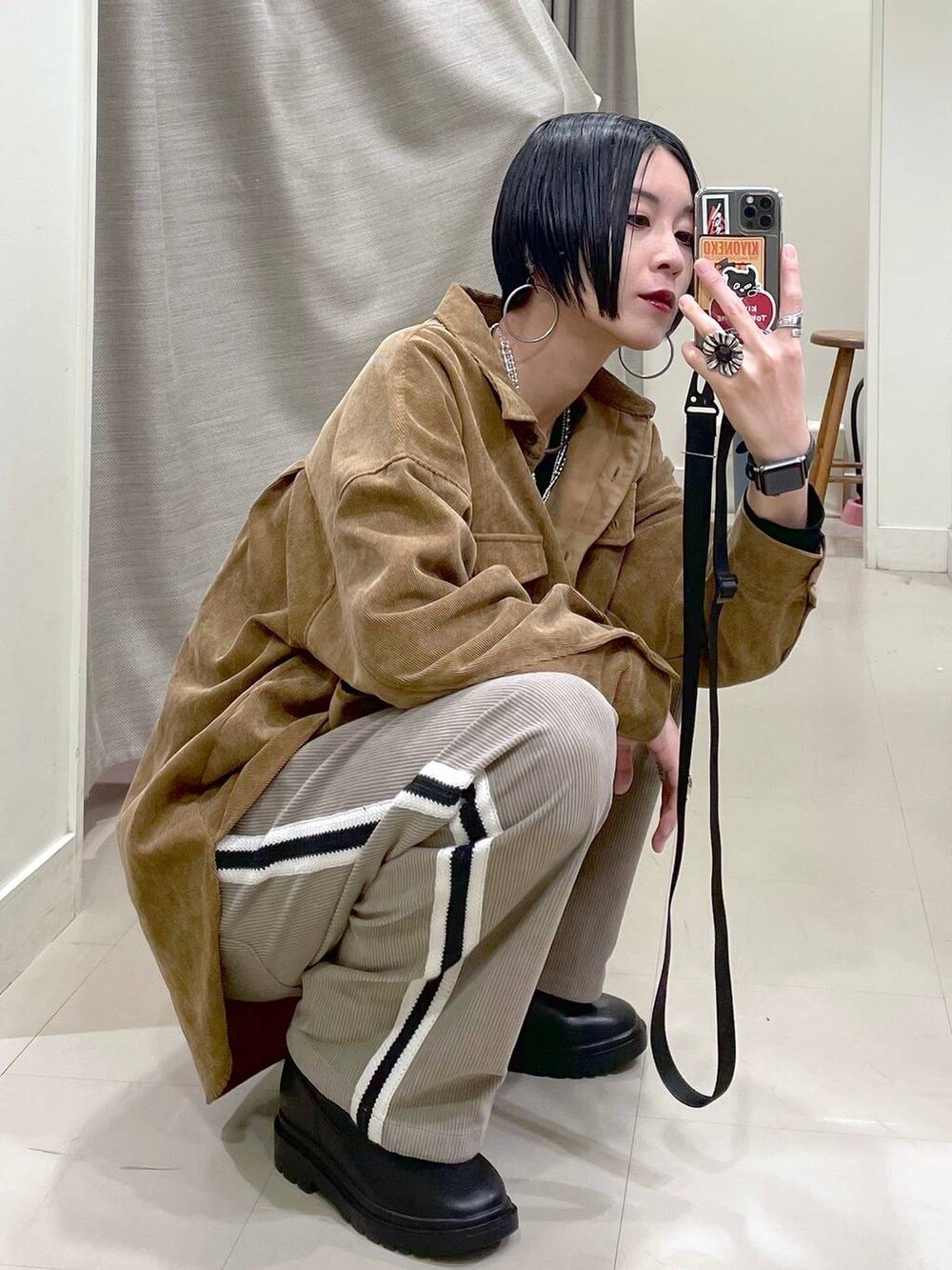 イエロー系のシャツ/ブラウス、ブラック系のスウェット、ブラック系のブーツを着用したレディースの秋コーディネートの5枚目の写真